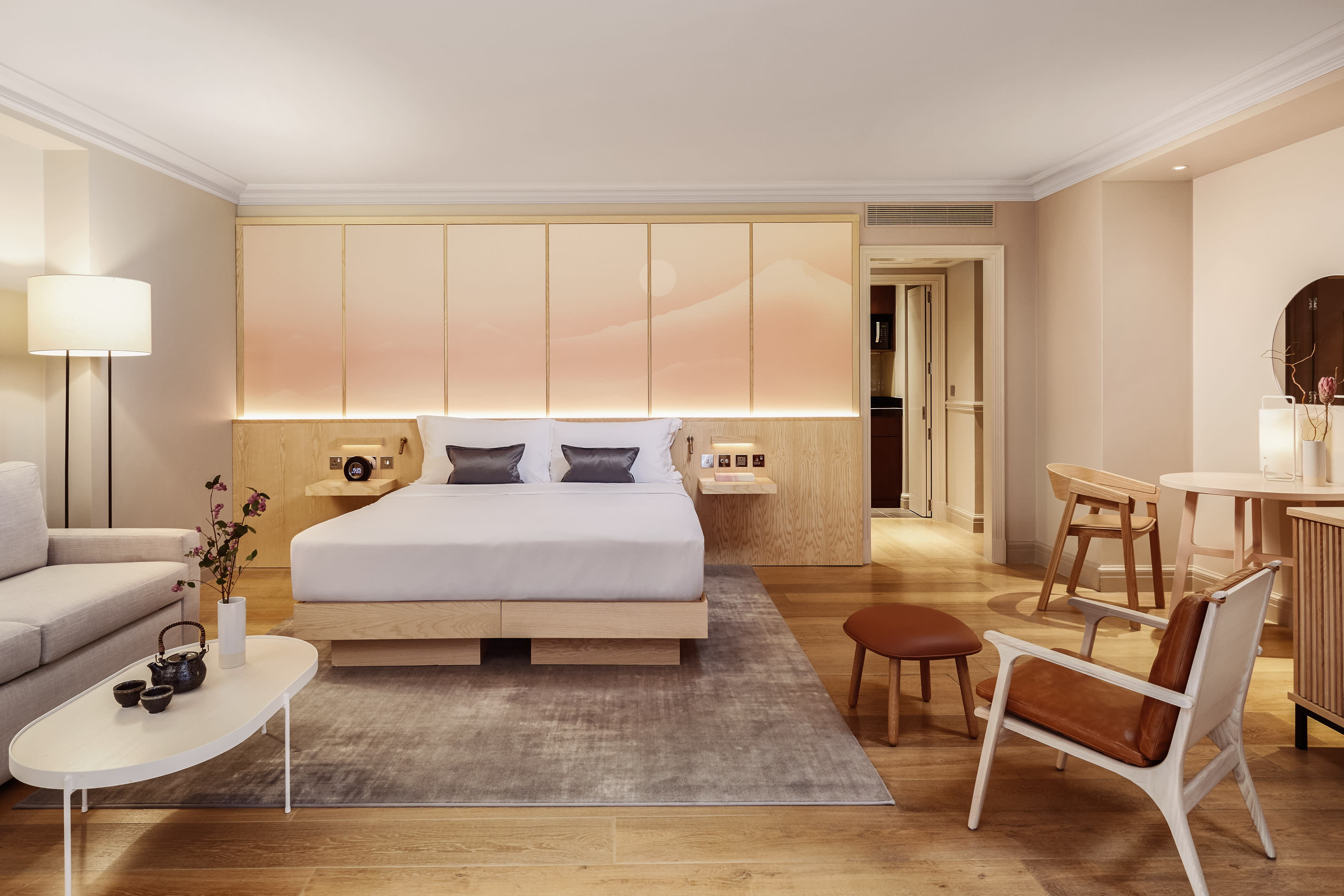 Hotel bedroom with neutral tones and wood furnishings