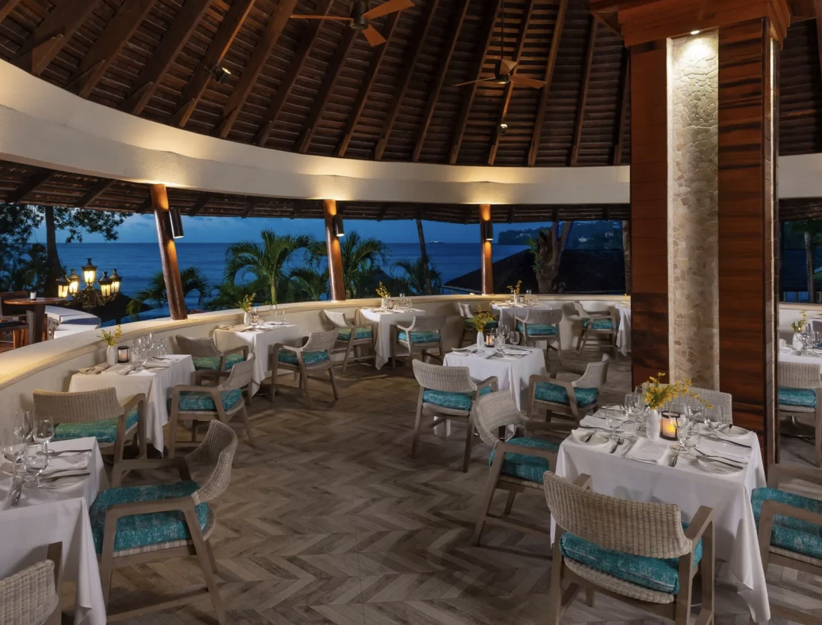 covered outdoor dining with evening lighting and an outdoor view