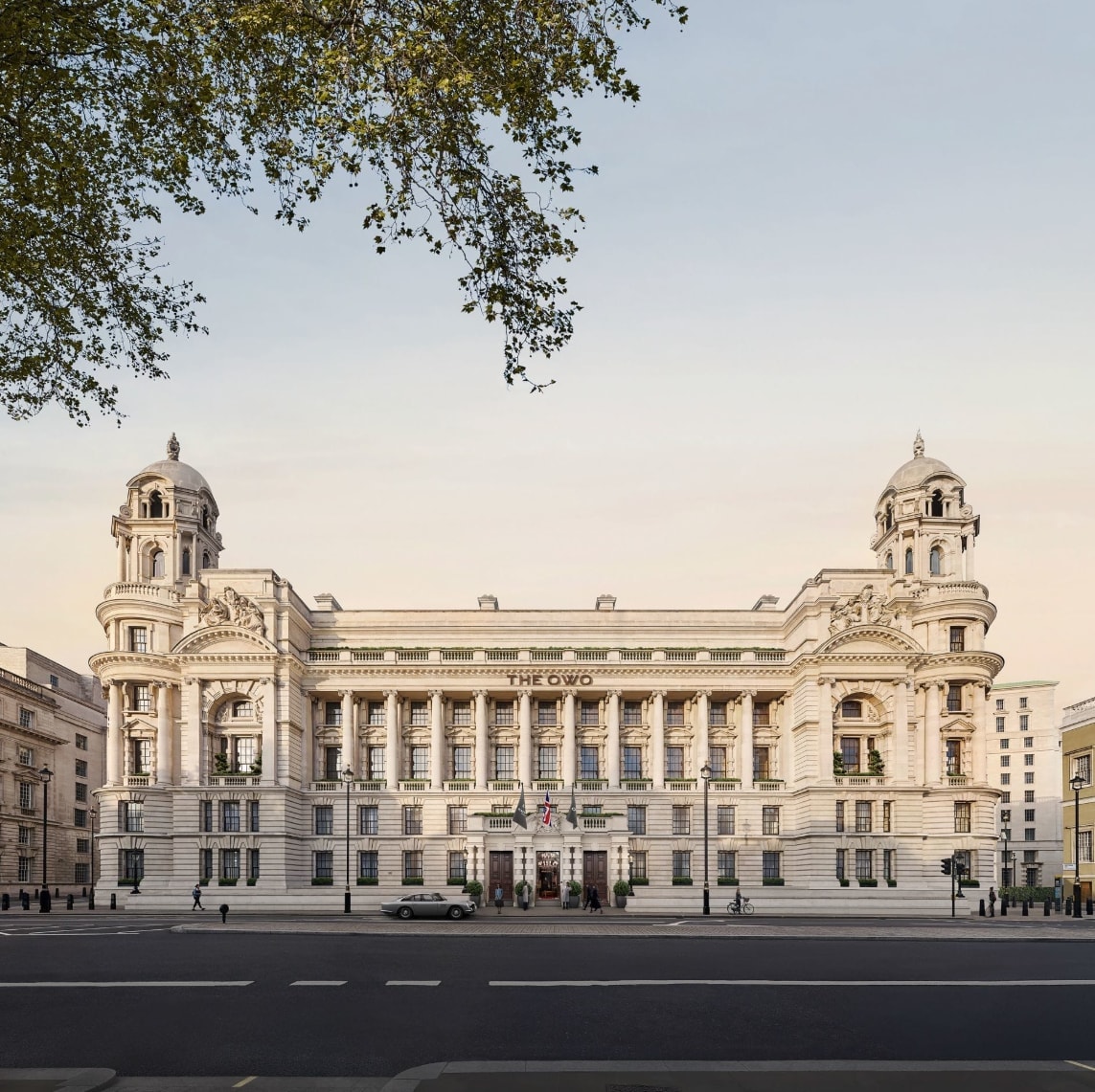 The grand white building of Raffles London hotel against a clear sky