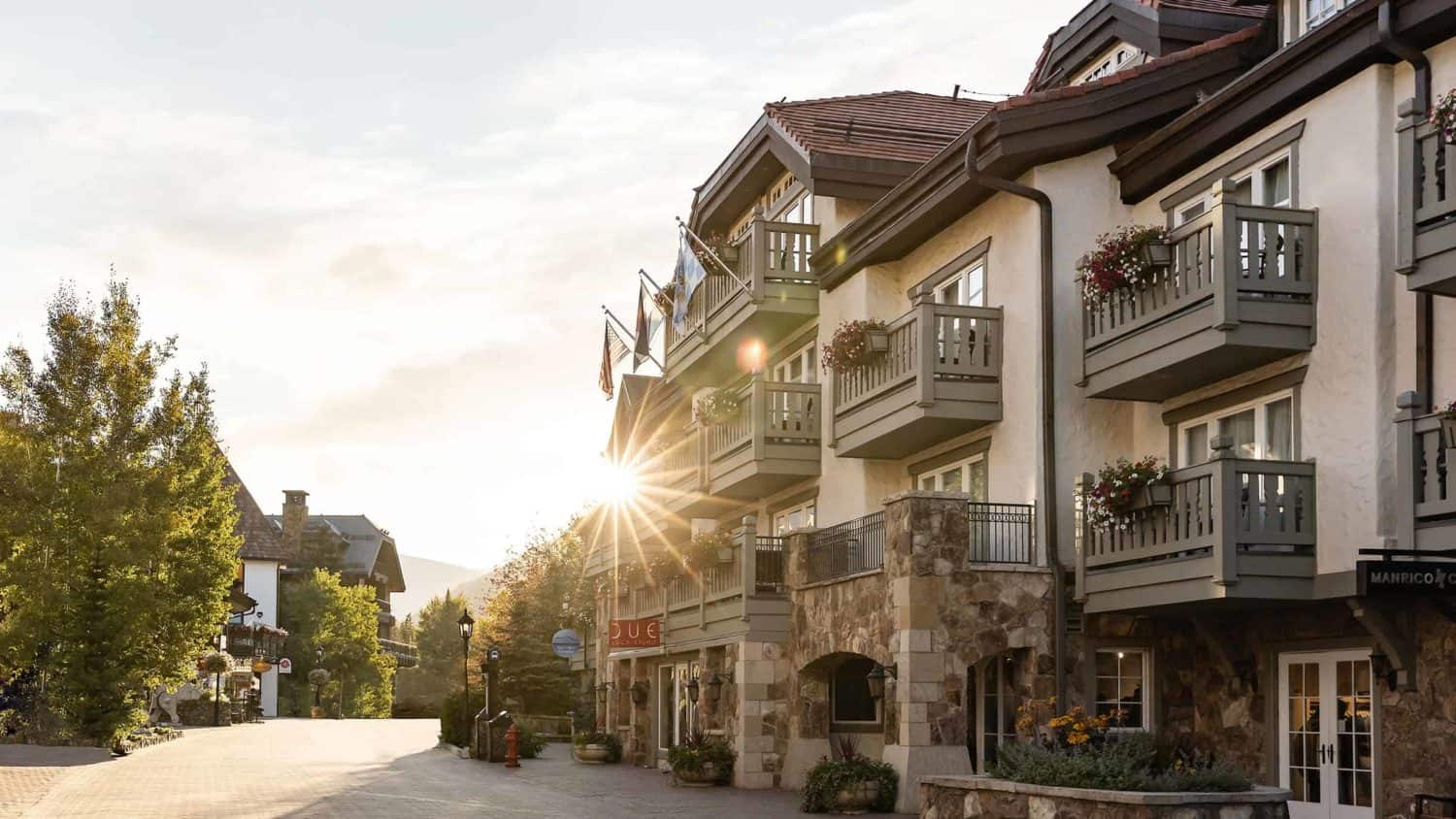 A European style hotel on an empty pedestrian street with the sun shining in the distance