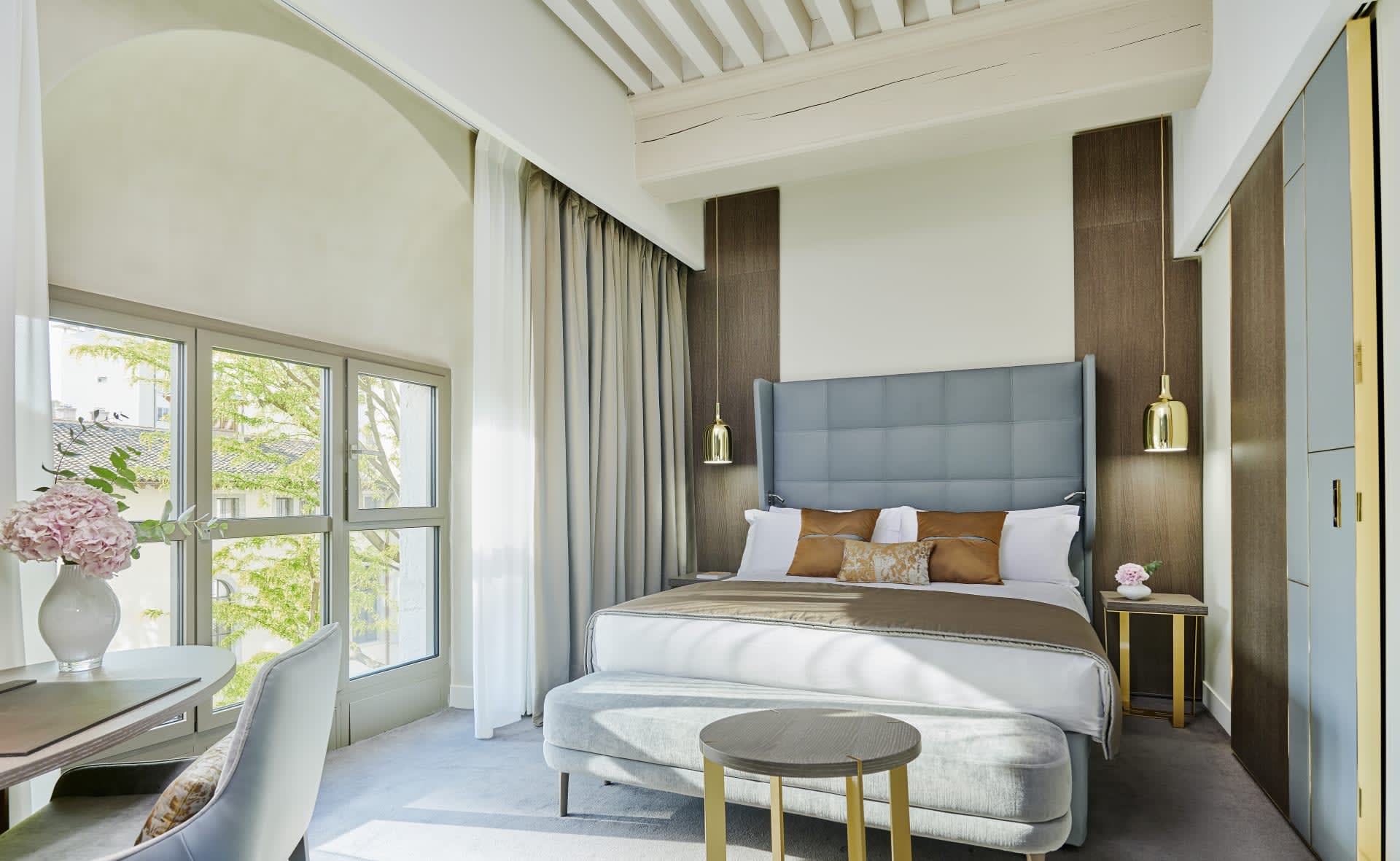 A contemporary room with dark wood accents, like blue bed headboard, white walls and white wood ceiling