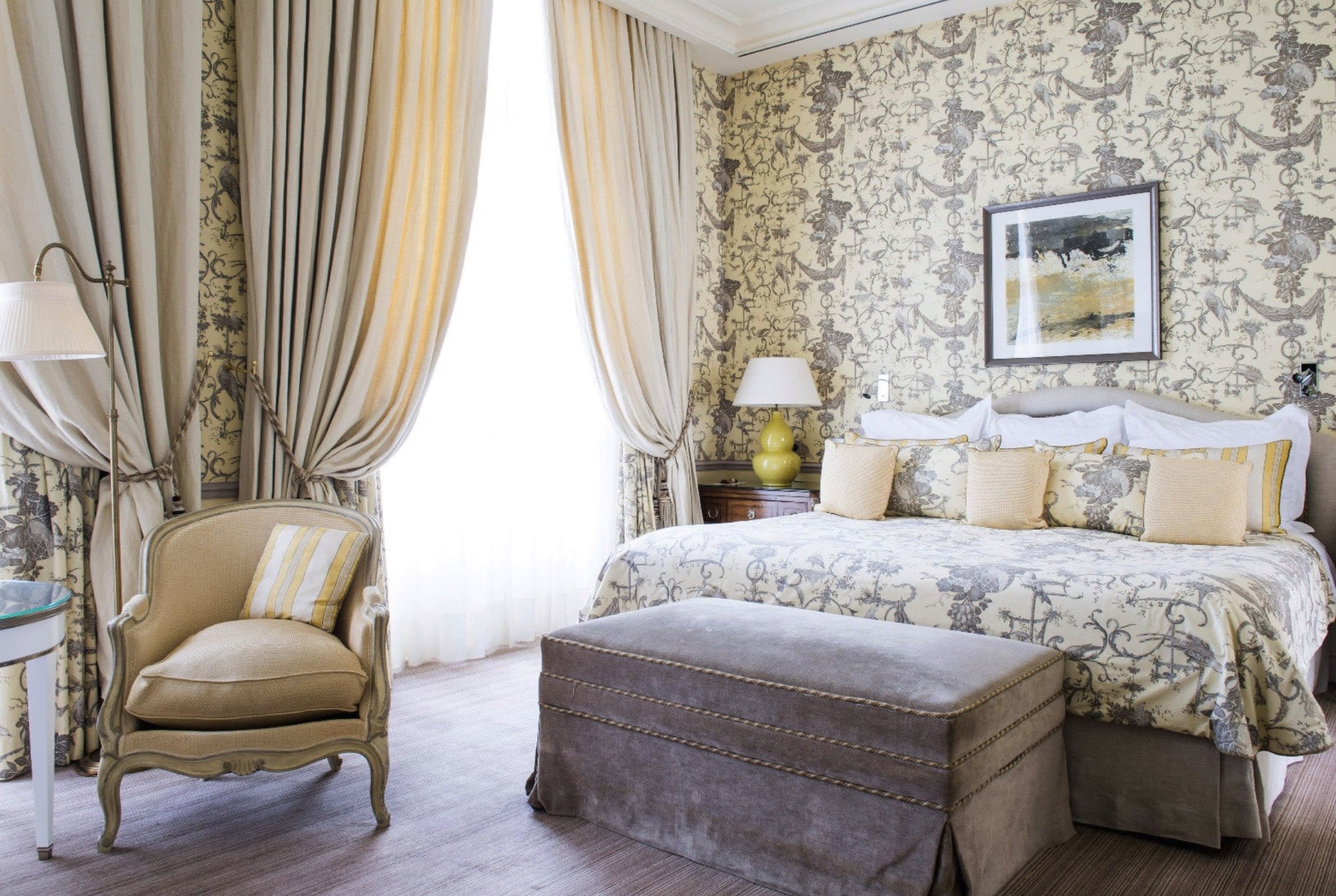 A bed with patterned walls, draperies and classic French decor