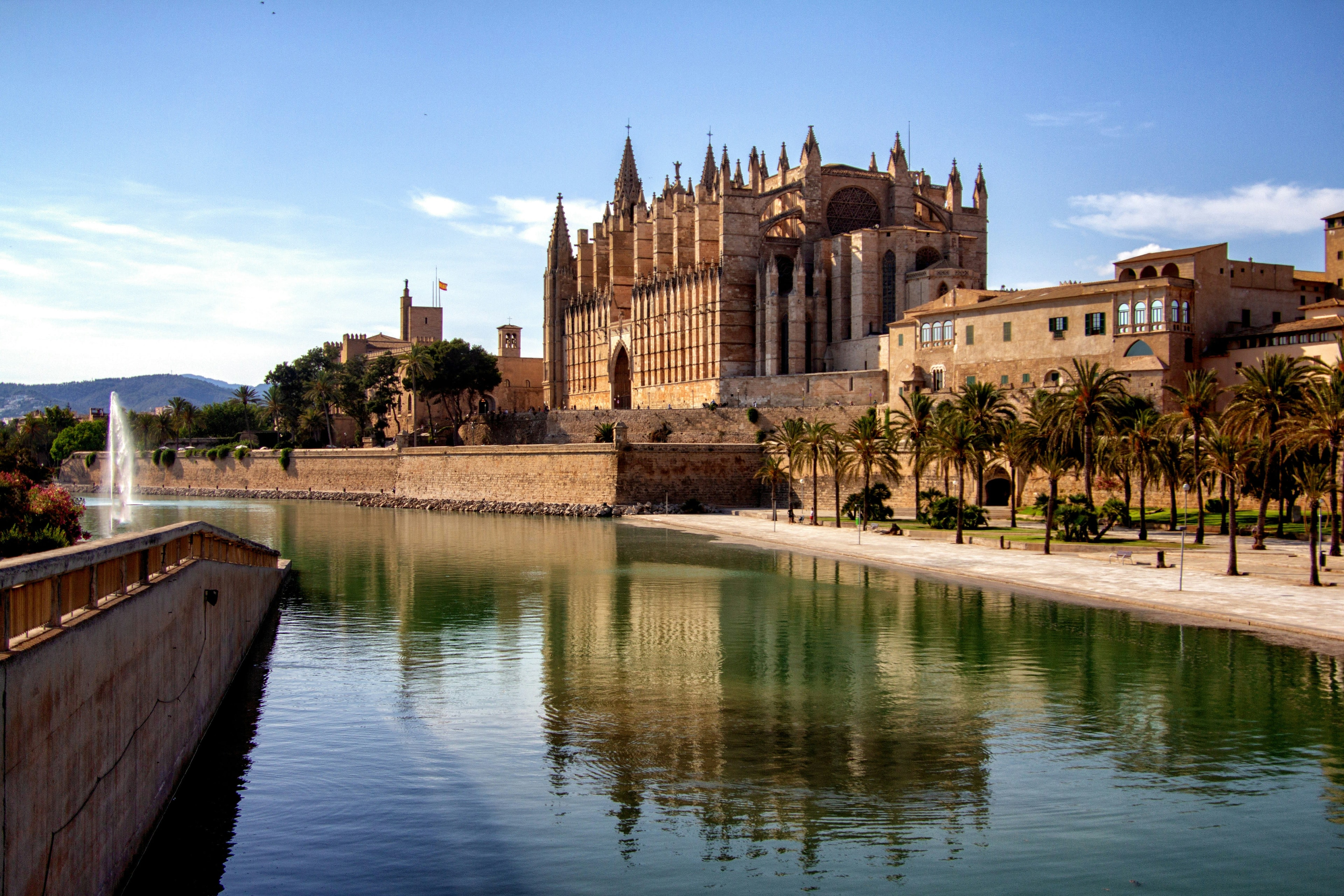 A river in front of a gothic style cathedral in afternoon sun
