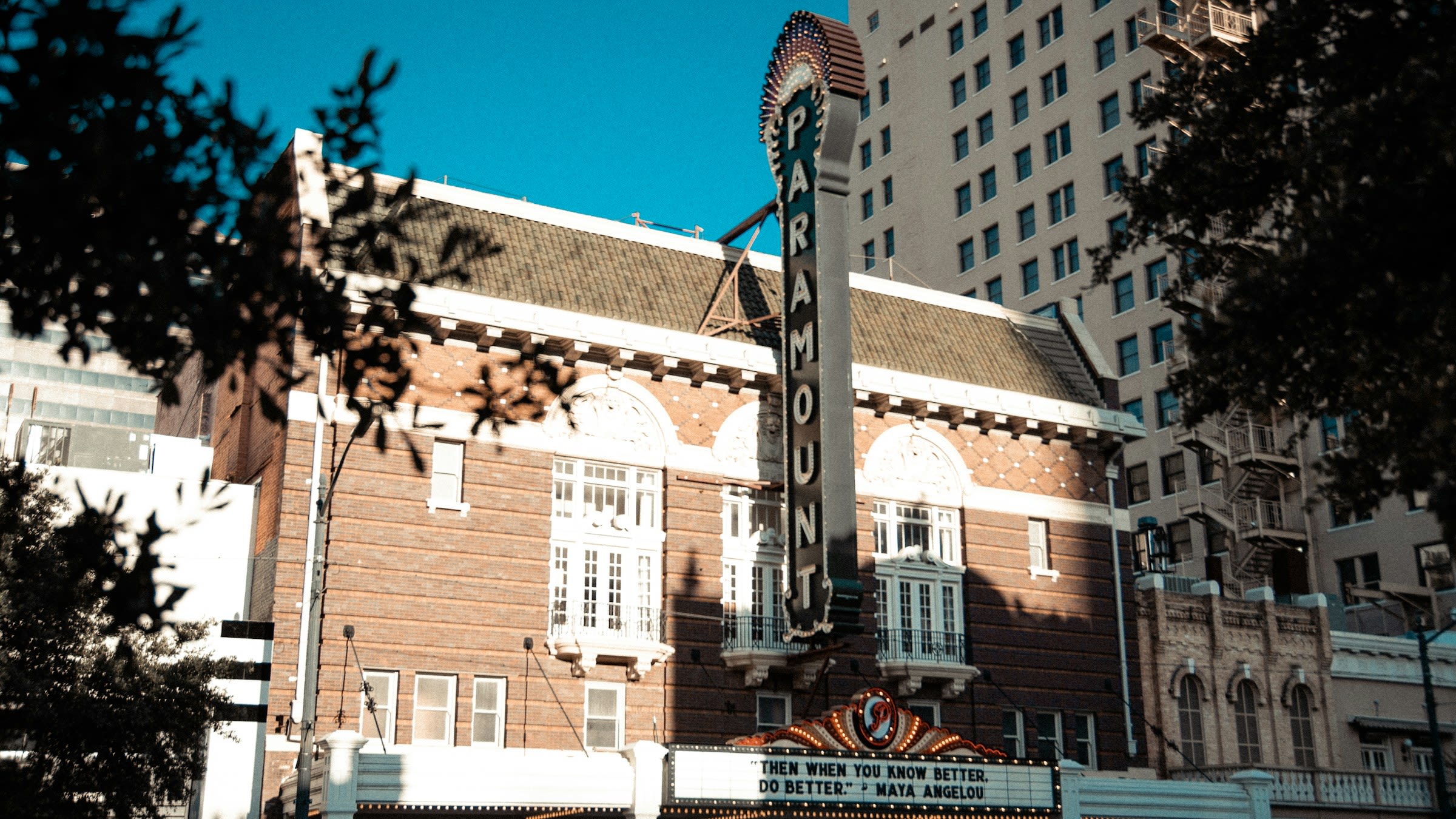 brown and white concrete building with a vertical marquee