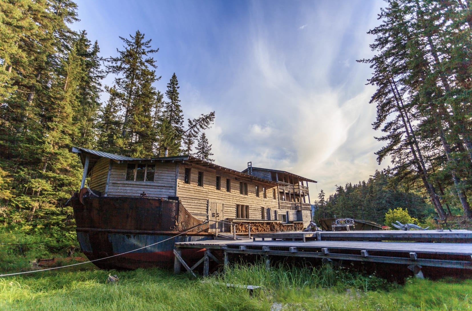 An exterior view of a cabin surrounded by pine trees in the daytime