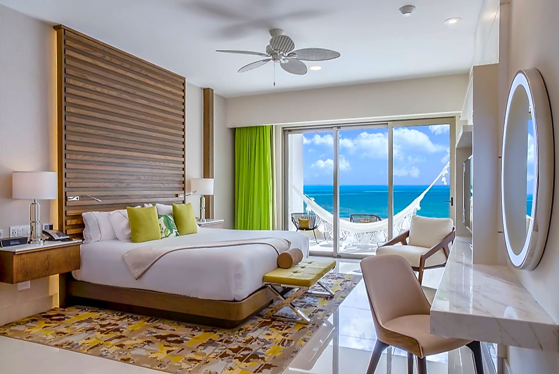 bright hotel room with a view to the ocean and a balcony