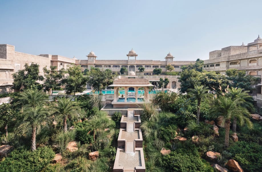 A grand imperial fort with an internal courtyard with tropical trees and bushes, plus a pool