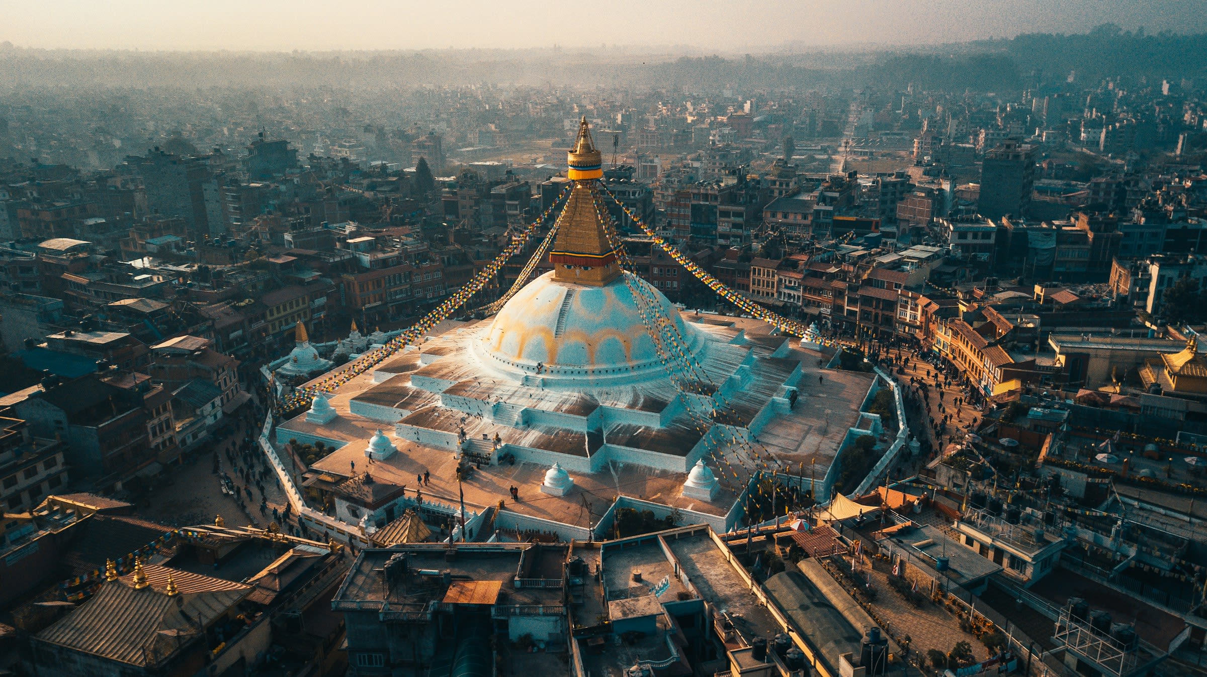 aerial view of city buildings during daytime with a rounded temple and gold spire in the middle