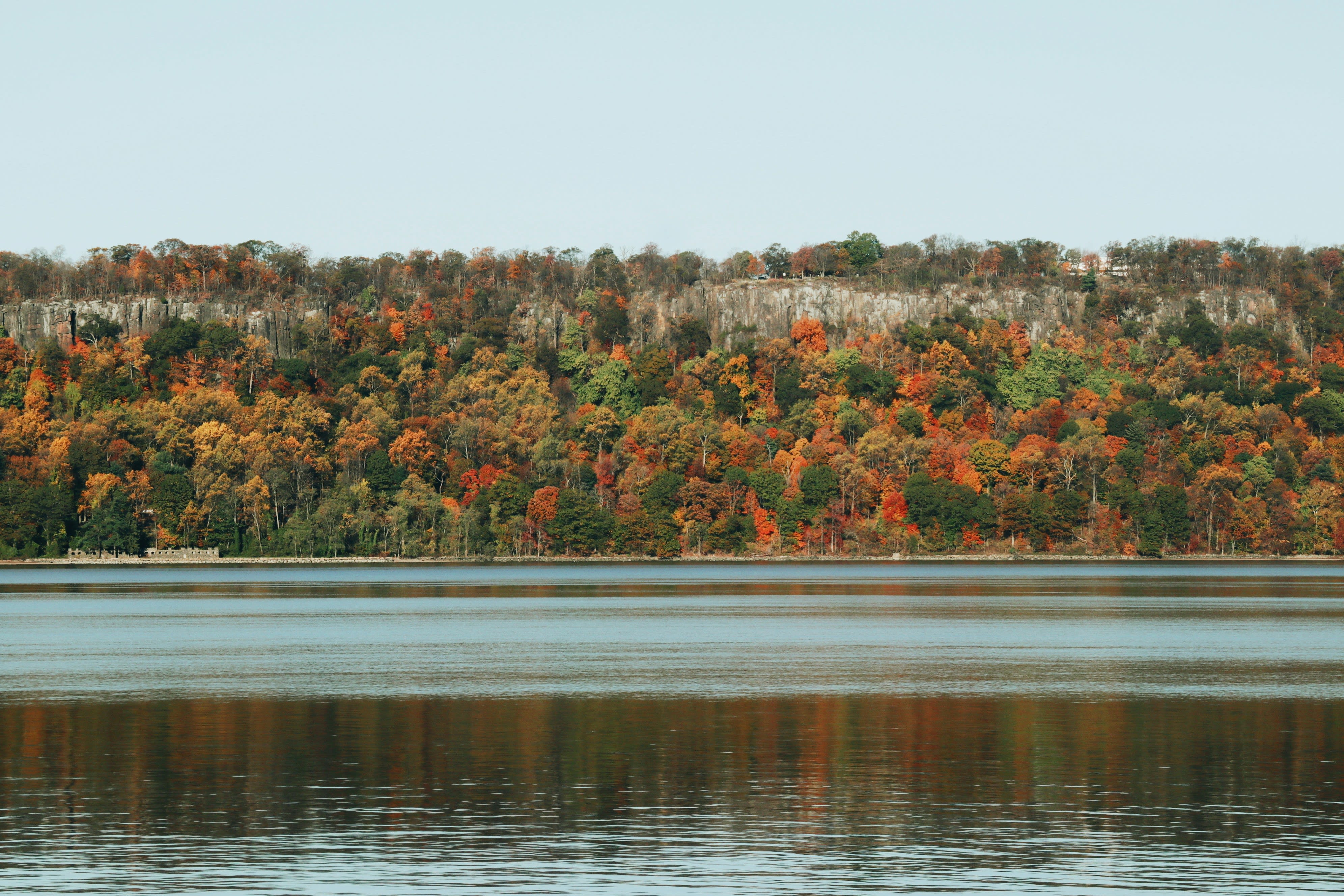 A view of the Hudson River and fall foliage in orange, green and yellow tones.