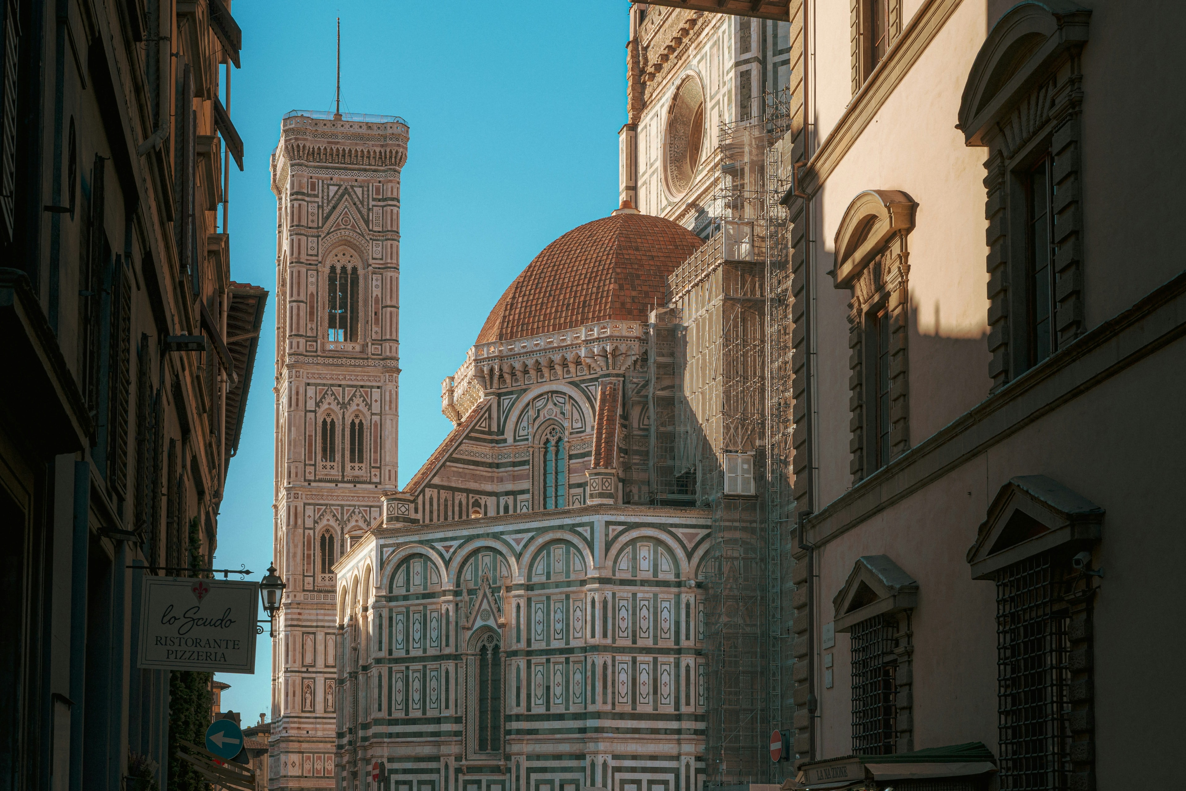 A view of a dome-shaped building and Florence cityscape against a blue sky