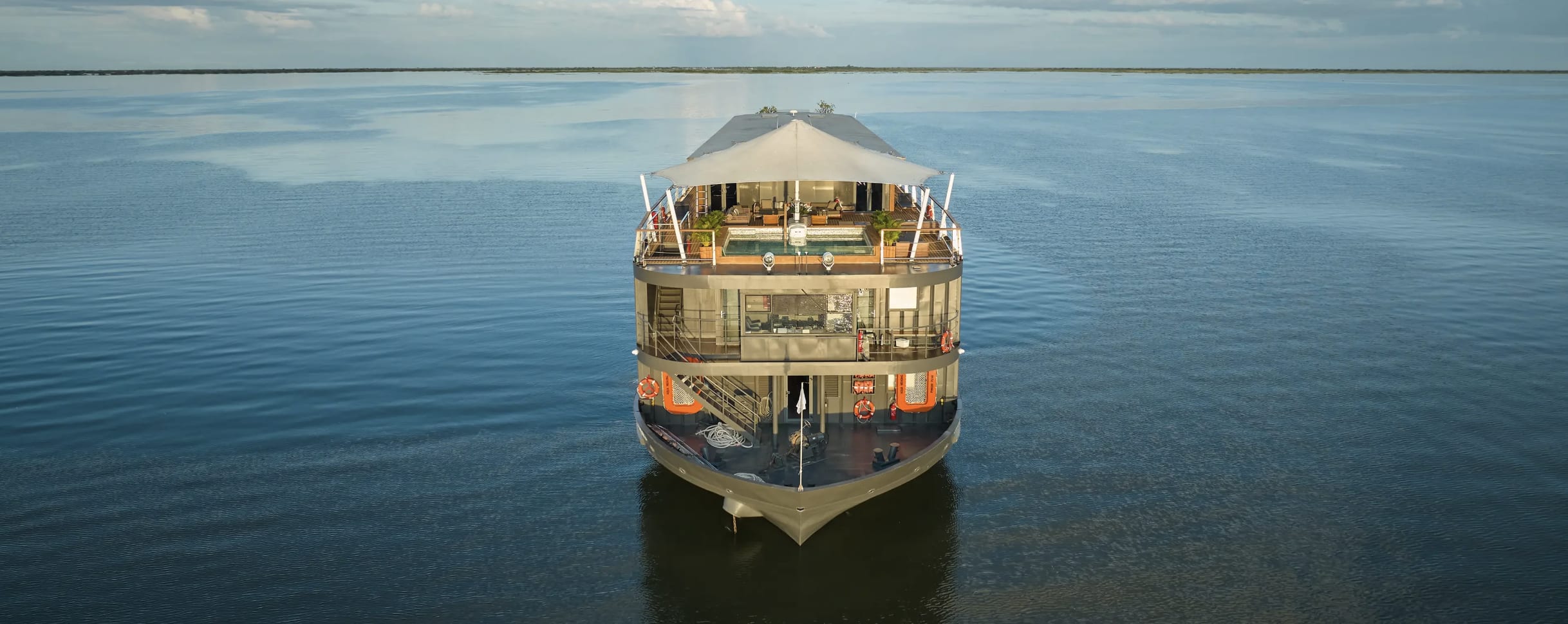 A two-story modern river boat on vast body of water