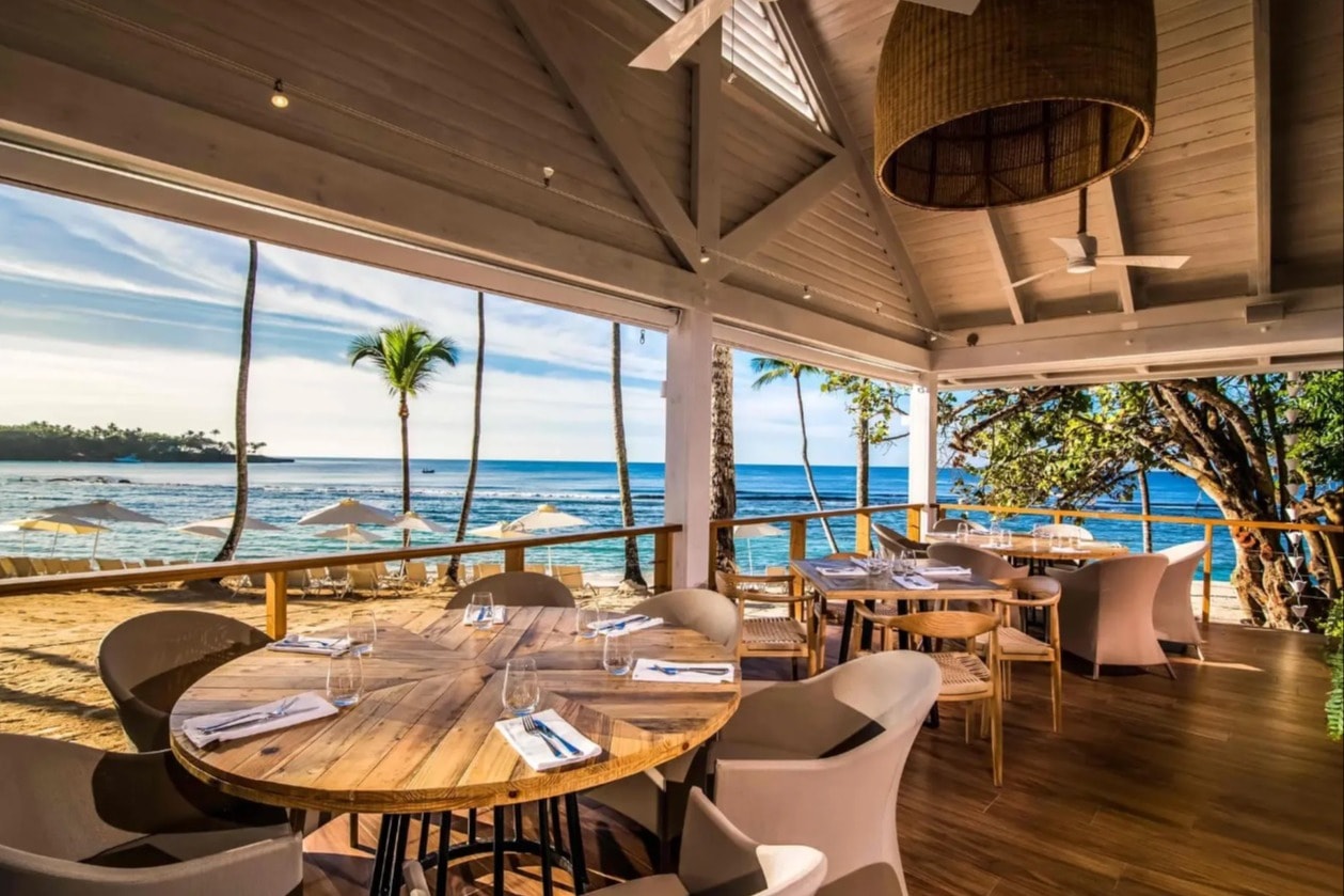 terrace restaurant with tables set for a meal and the sea beyond