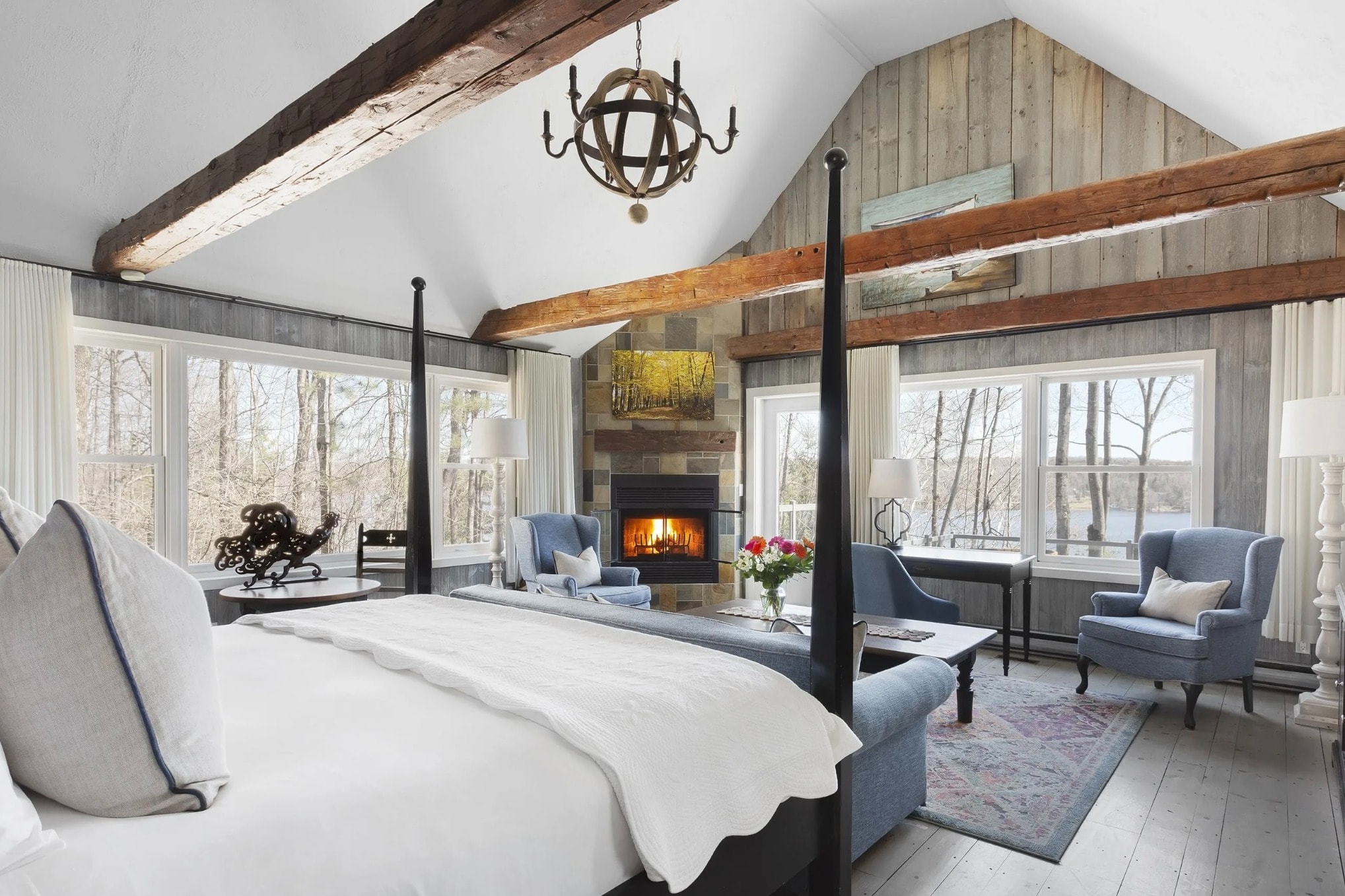 bedroom with vaulted ceilings, wood beams and a fireplace