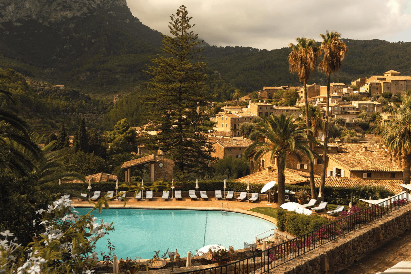 aerial view of an outdoor pool near a cliffside village of stone houses