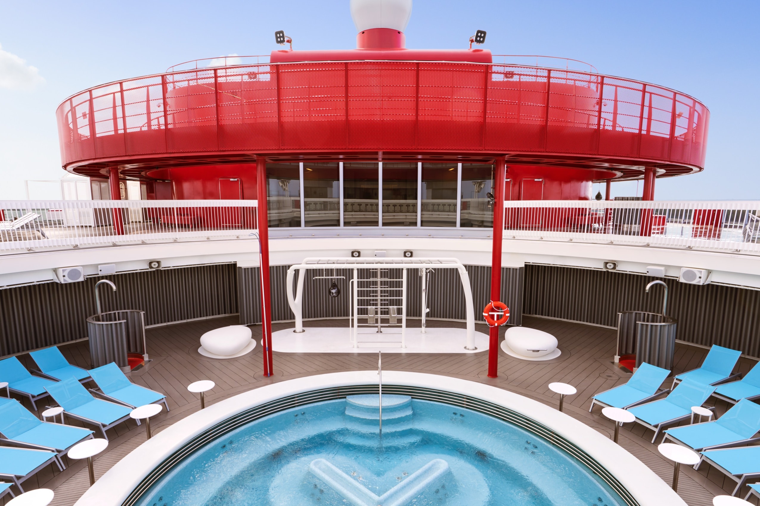 outdoor pool surrounded by blue lounge chairs on a cruise ship deck