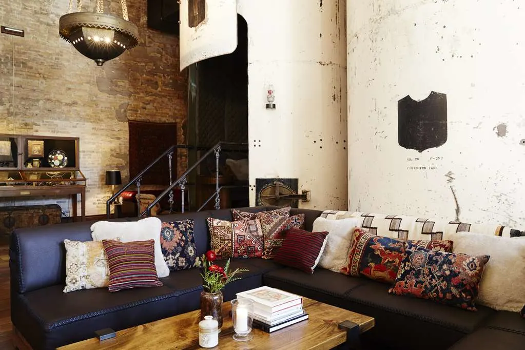 a navy-blue L-shaped couch with colorful pillows in a sun-filled room