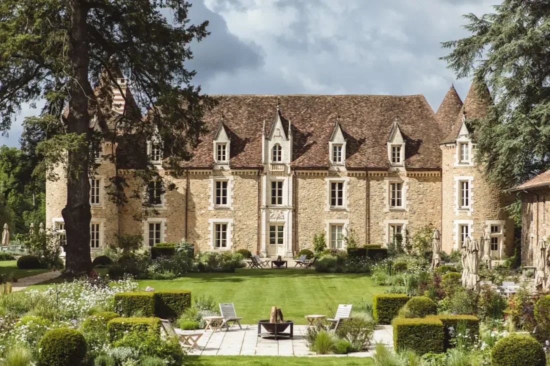 a multi-story countryside château with a manicured lawn