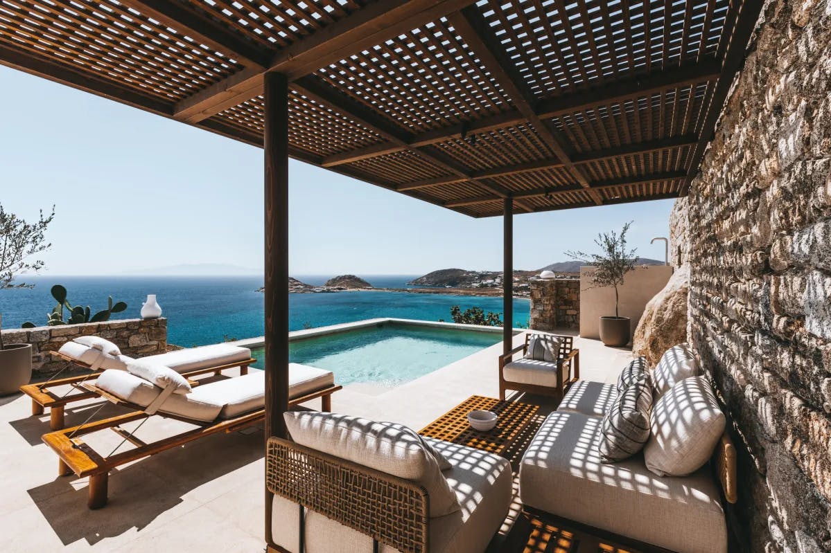 white loungers and a plunge pool on a terrace overlooking the sea