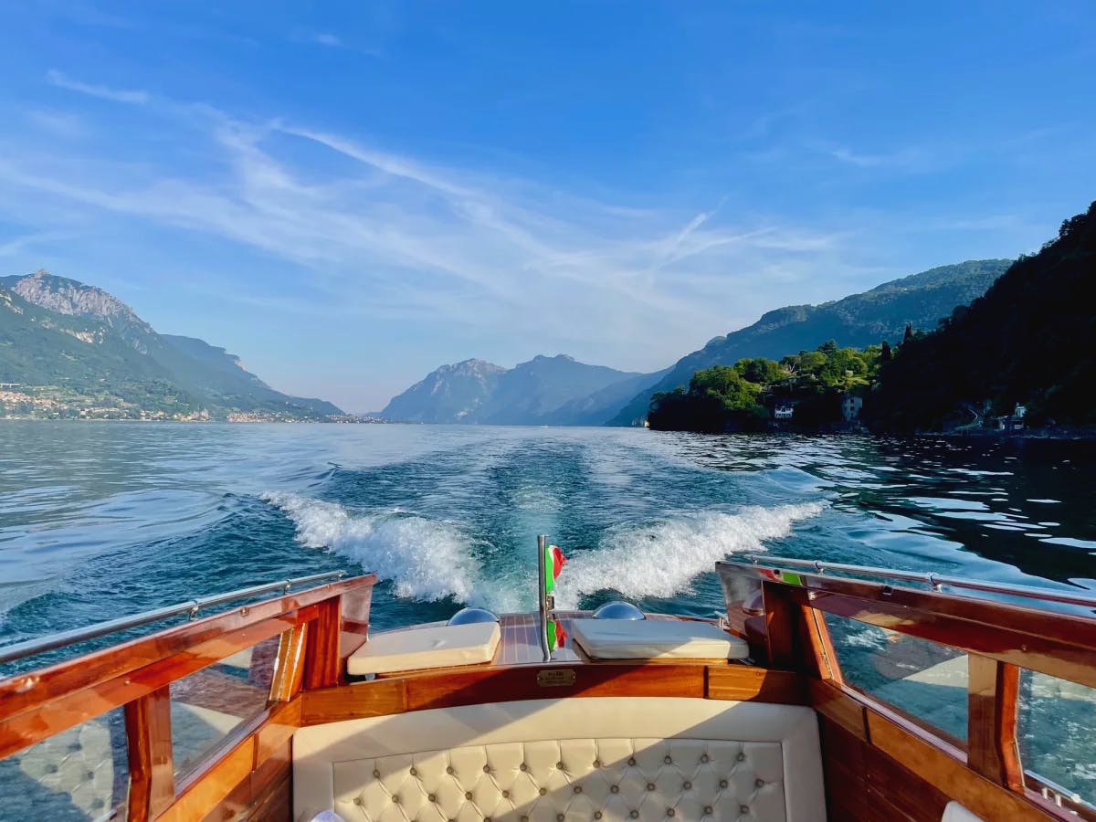 The back of a boat cruising through a lake during a sunny day