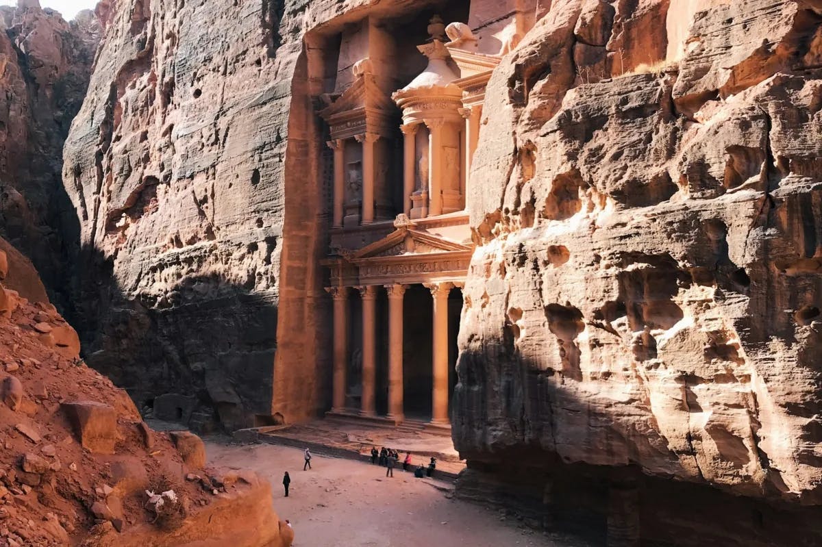 Built into the walls of a canyon somewhere in the Middle East, an ornately carved temple that towers over nearby travelers