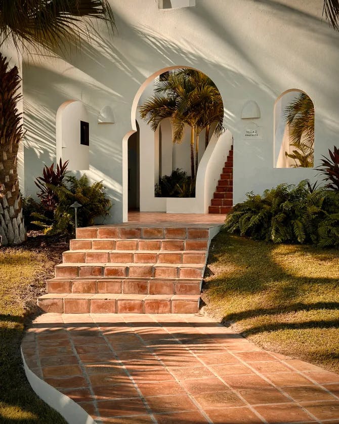 A picture of Cap Juluca, A Belmond Hotel, Anguilla with a stone pathway and staircase leading to an arched doorway