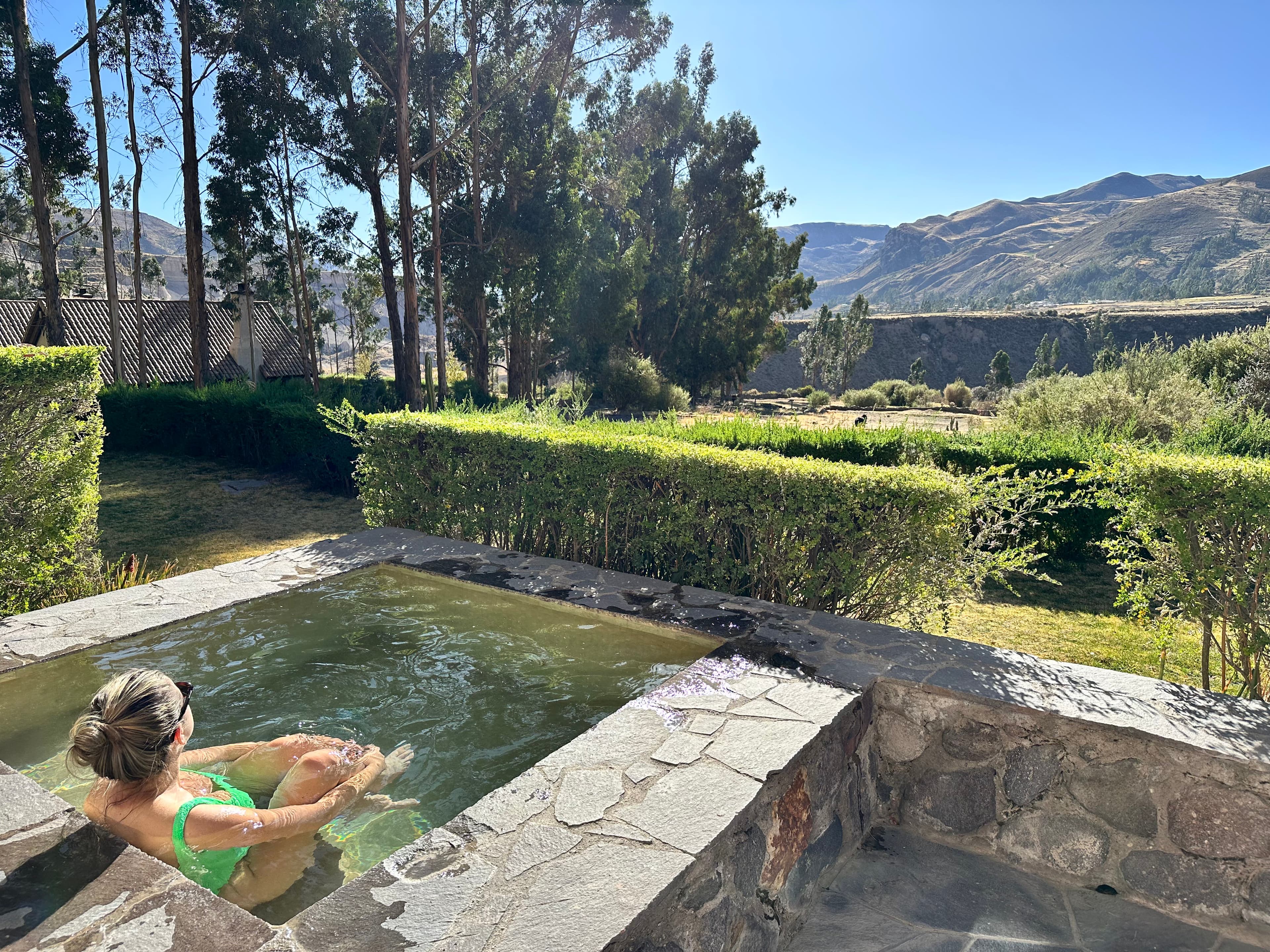 Travel advisor posing in a pool in a valley