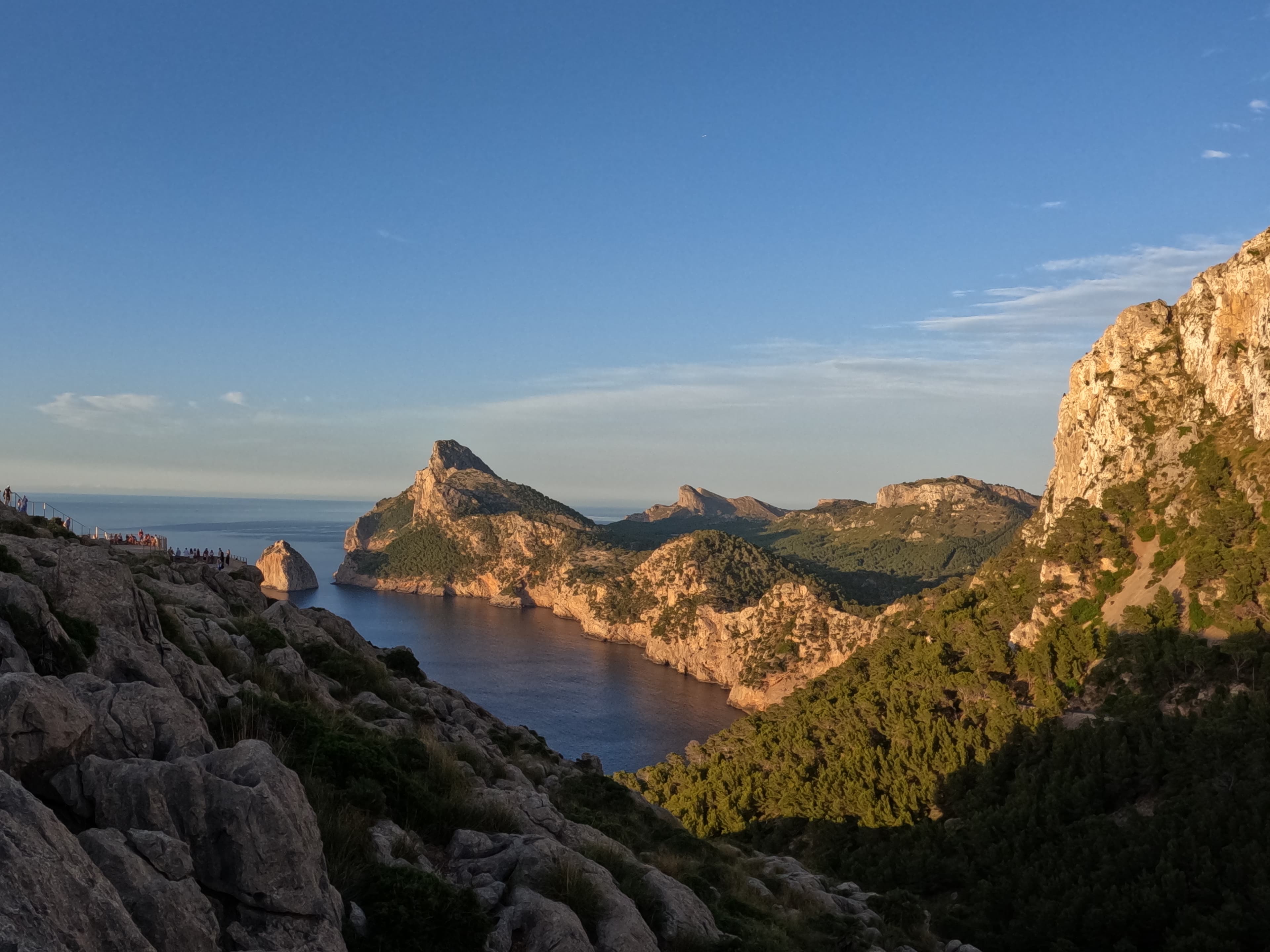 A view of rocky mountains and blue sea in the distance.