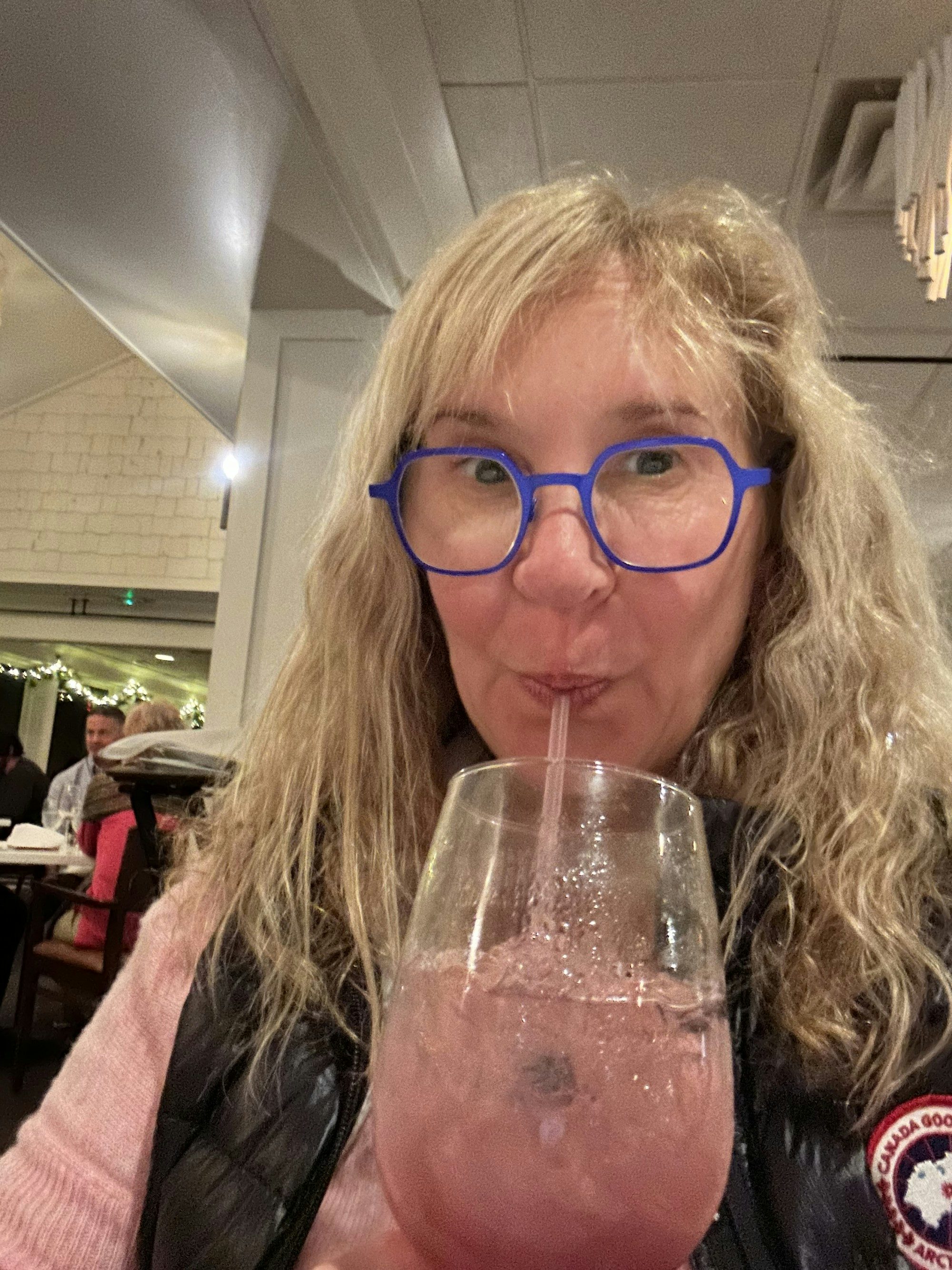 Travel Advisor Michele Buring sips on a pink cocktail with ice and a straw
