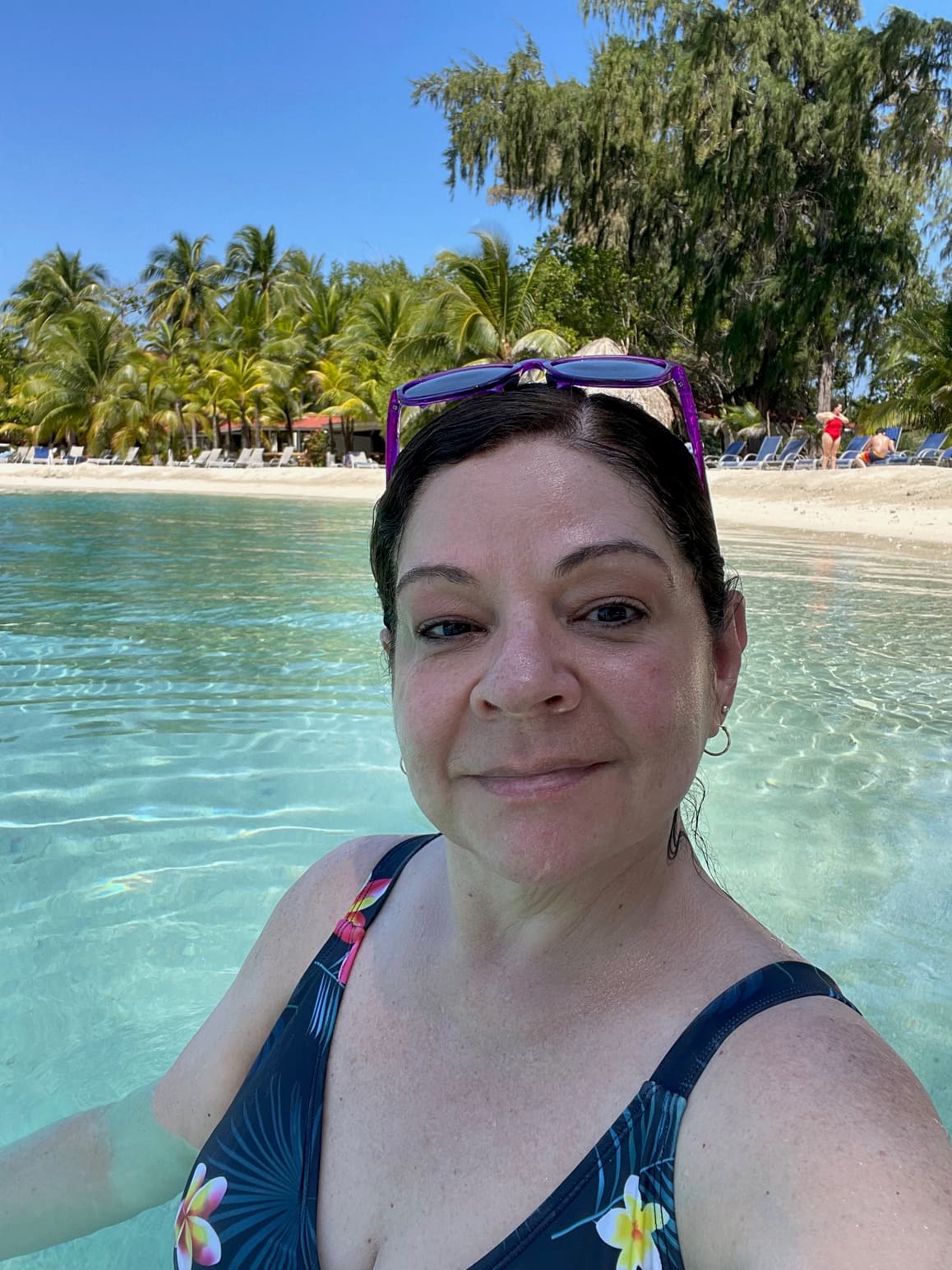 Jamie taking a selfie in the clear, turquoise waters of a tropical beach.