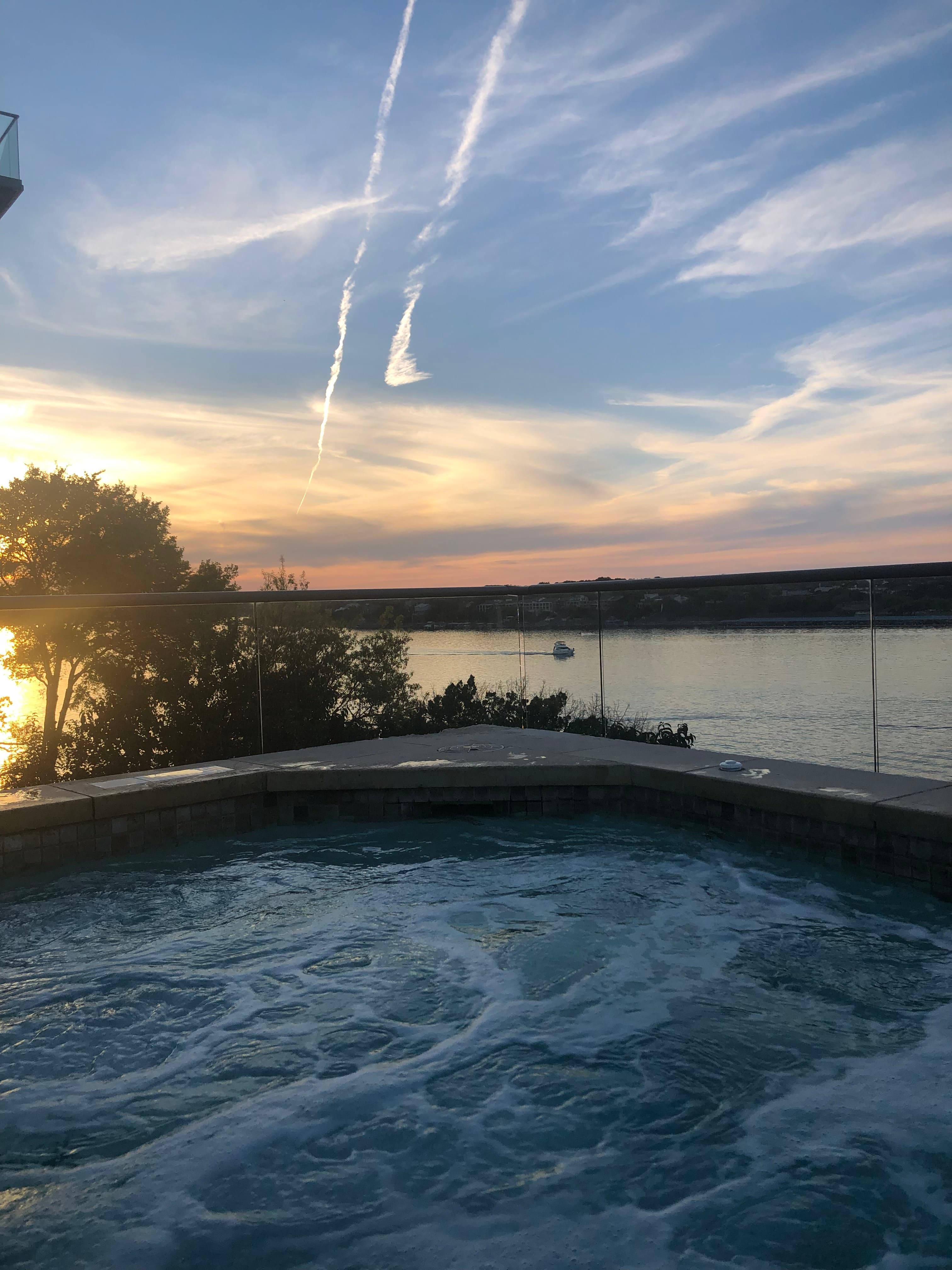A jacuzzi overlooking a body of water at sunset