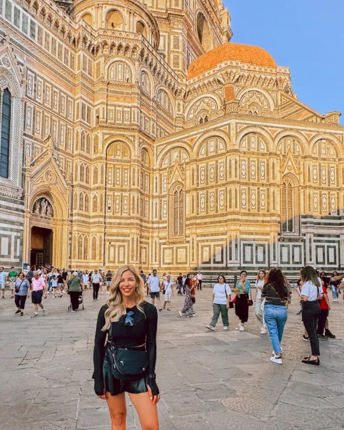 A picture of Morgan wearing a black outfit and posing in front of the Cathedral of Santa Maria del Fiore 
