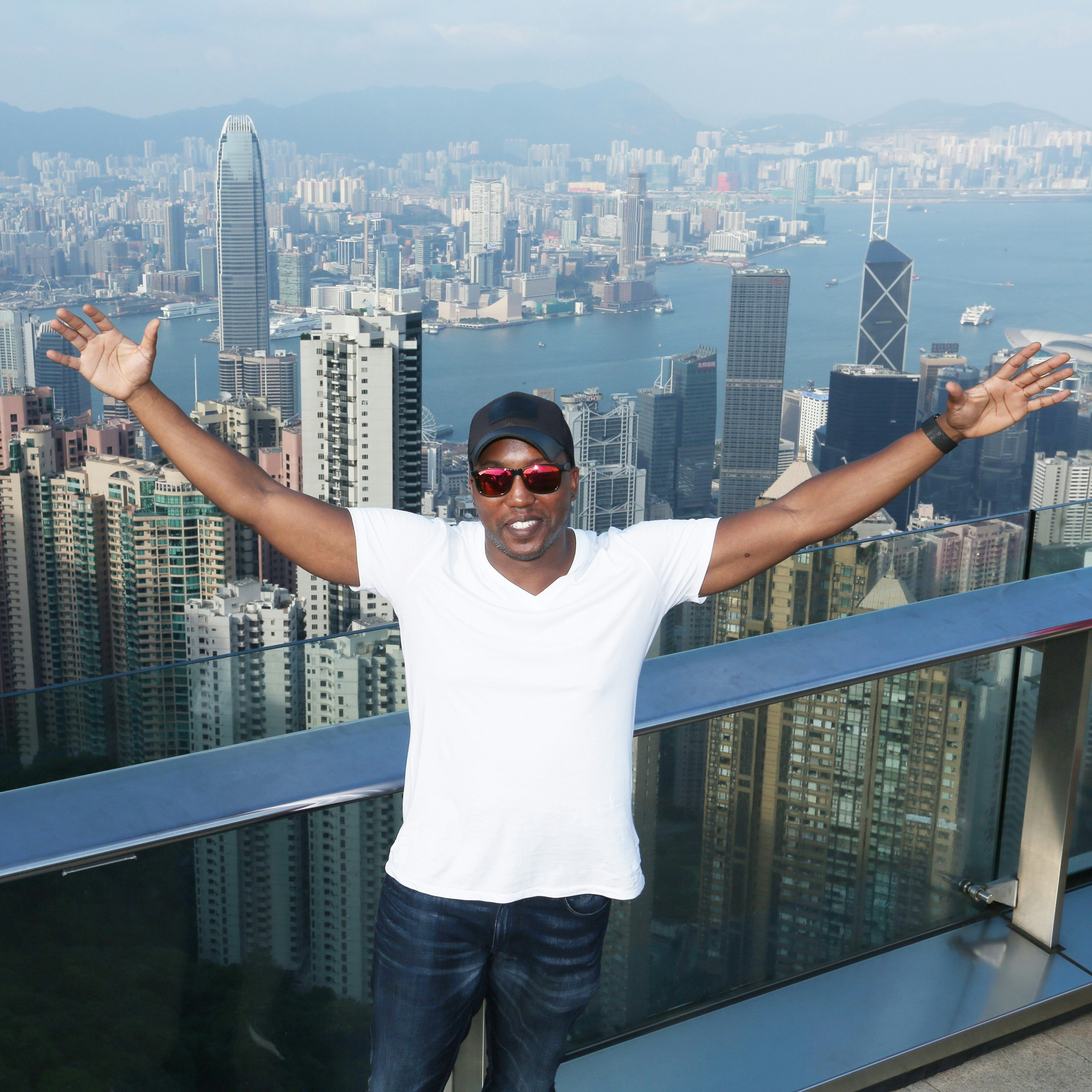 Travel Advisor Rollo Reese with a white t-shirt, jeans and a black hat at Victoria's Peak in Hong Kong.