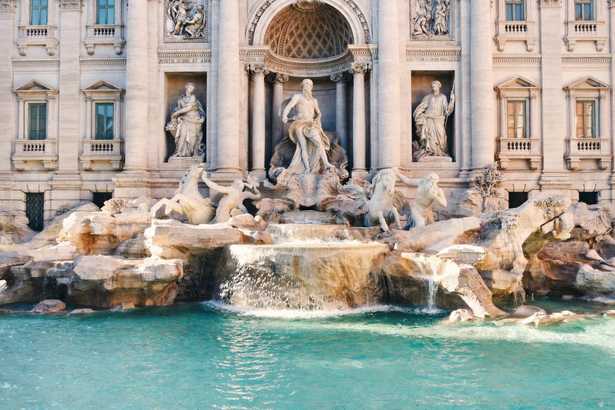 A picture of the Trevi Fountain with concrete structures during daytime.