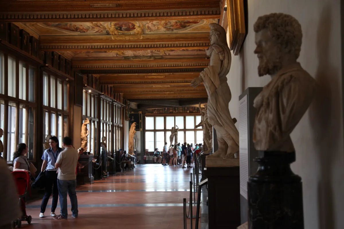 People in a gallery with statues. 