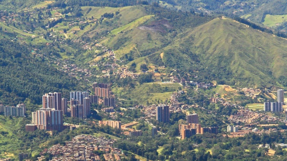 Aerial view of city with high rises and a mountain view