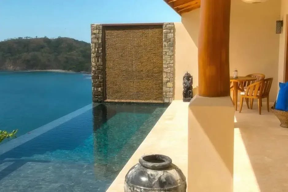 View of a patio of a private suite at Casa Chameleon Las Catalinas in Costa Rica: an infinity pool offers a view out over the coast at Las Catalinas