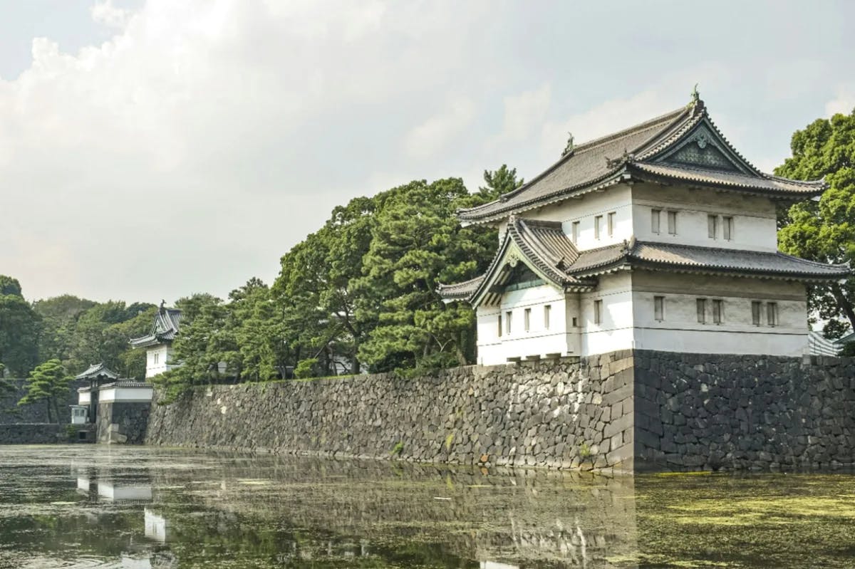 Moss-filled water leads up to sharp cobblestone walls and Edo-era Japanese historic architecture in Chiyoda City
