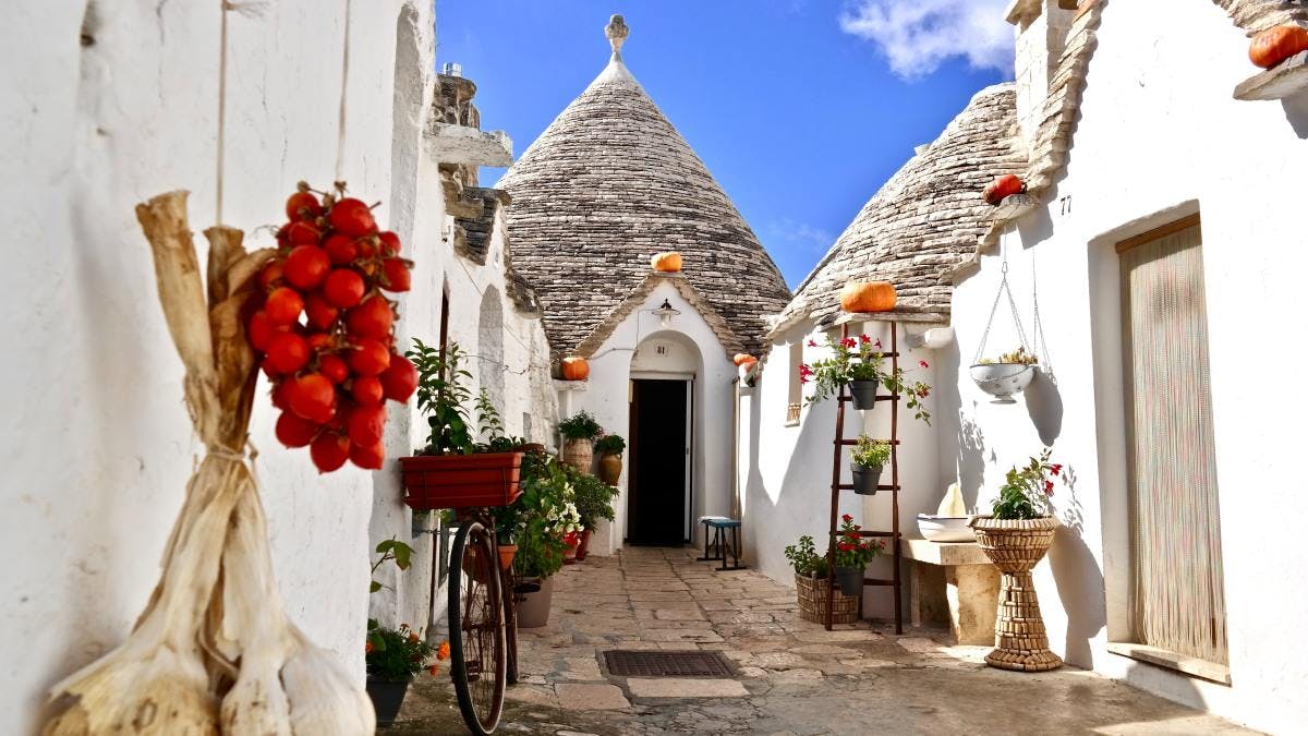 White buildings, cobblestone streets and narrow walkway in Puglia, Italy.