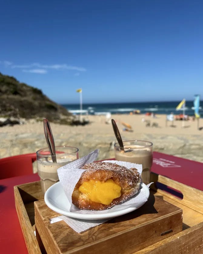 A pastry and coffee on the beach