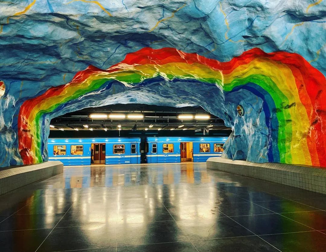 A subway with a colorful rainbow painting on the wall and ceiling.