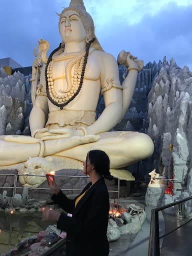 Girl with candle next to buddha.