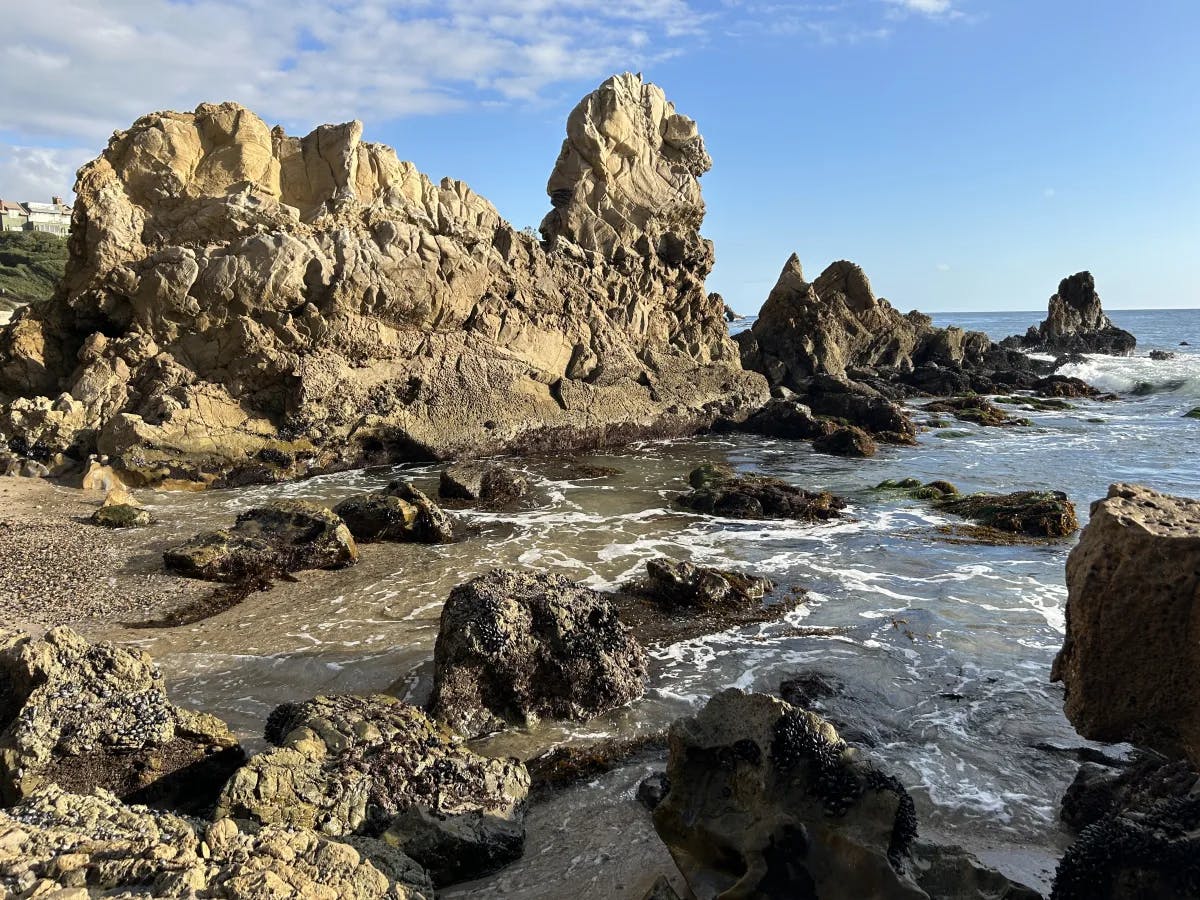 A beautiful Newport Beach seaside with a rock formations and clear skies.