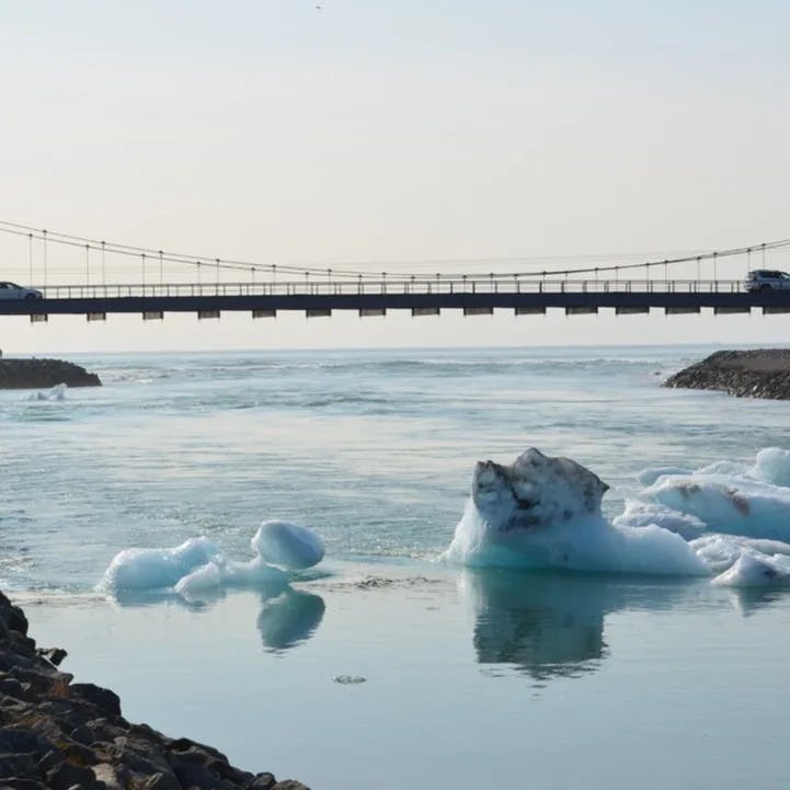 A bridge over a lake with frozen parts.