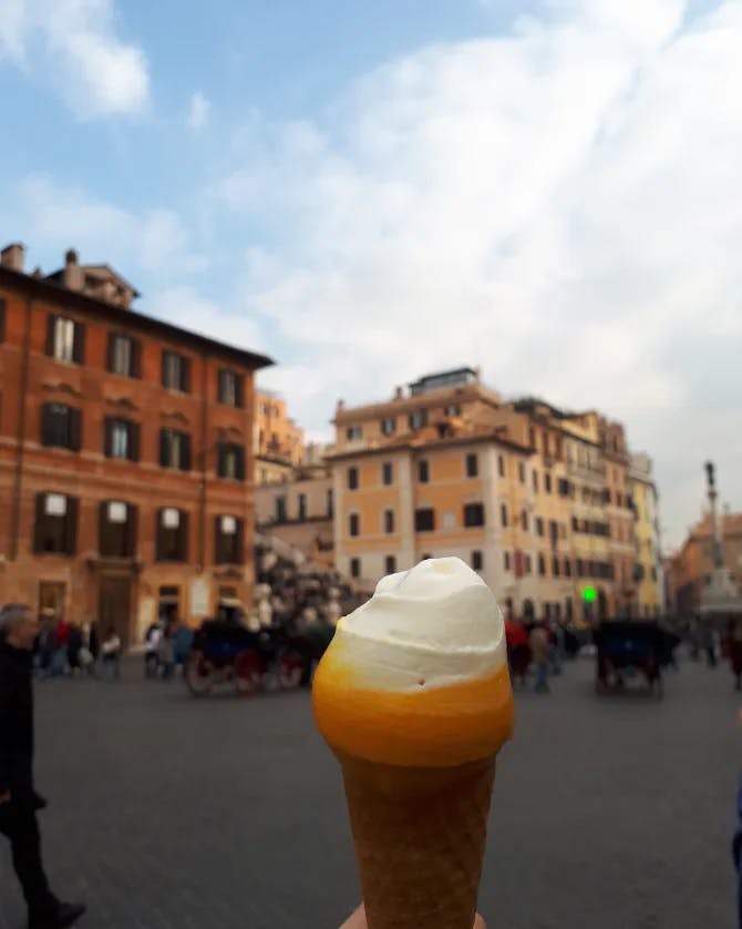 Delicious gelato treat in a cone with city square in the background. 