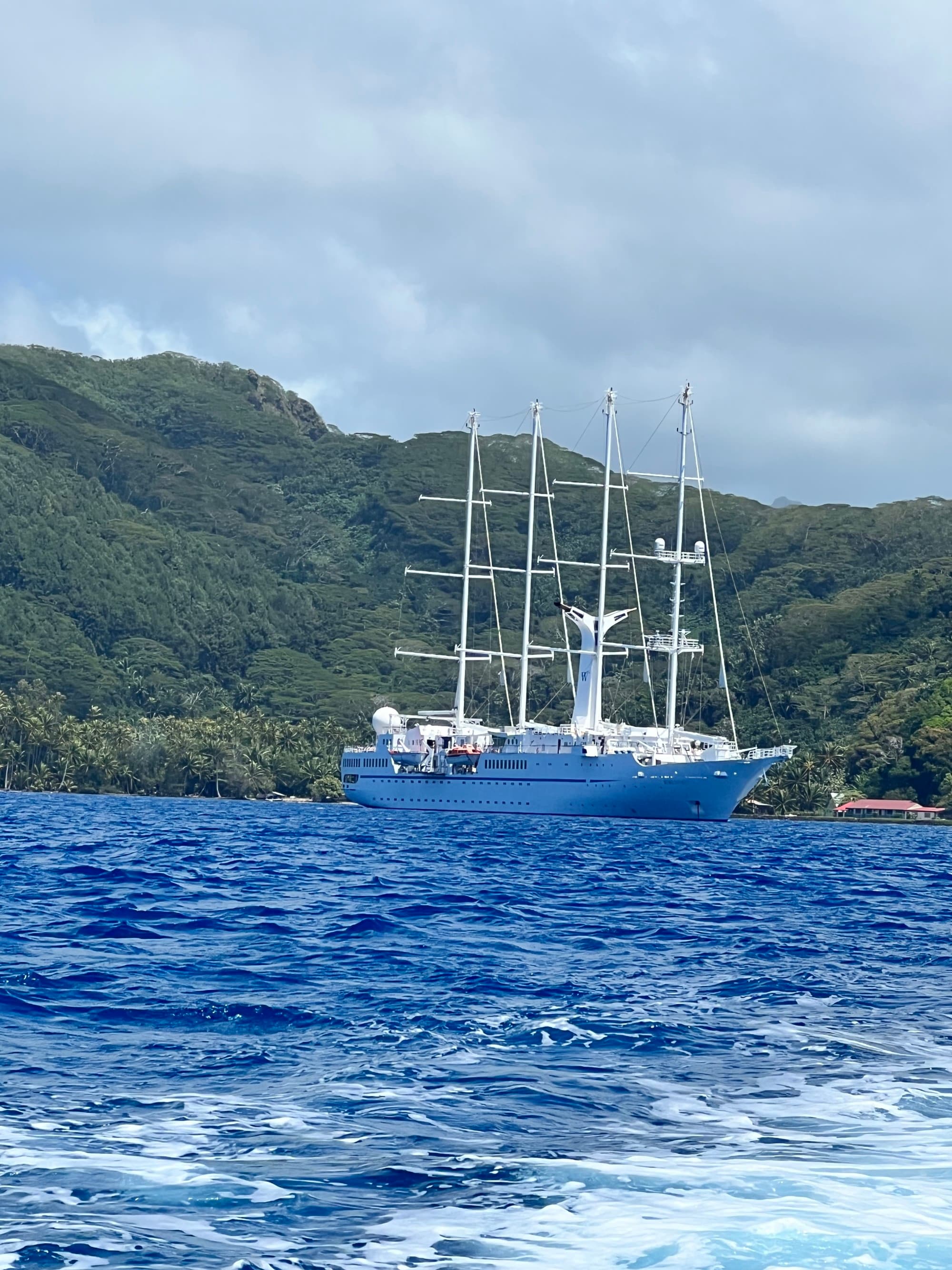 A white boat on water with mountains at the back.