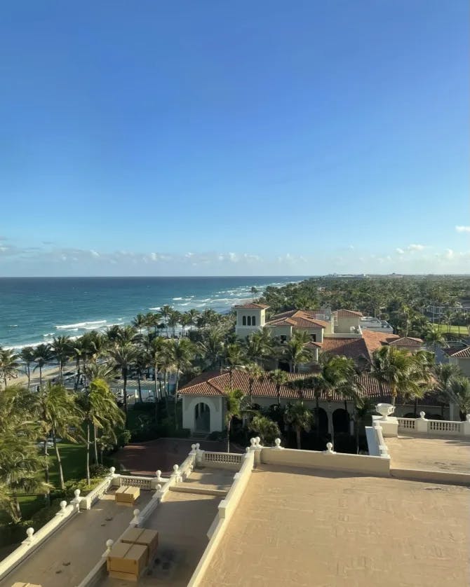An aerial view of The Breakers Palm Beach hotel with the ocean and blue sky in the background