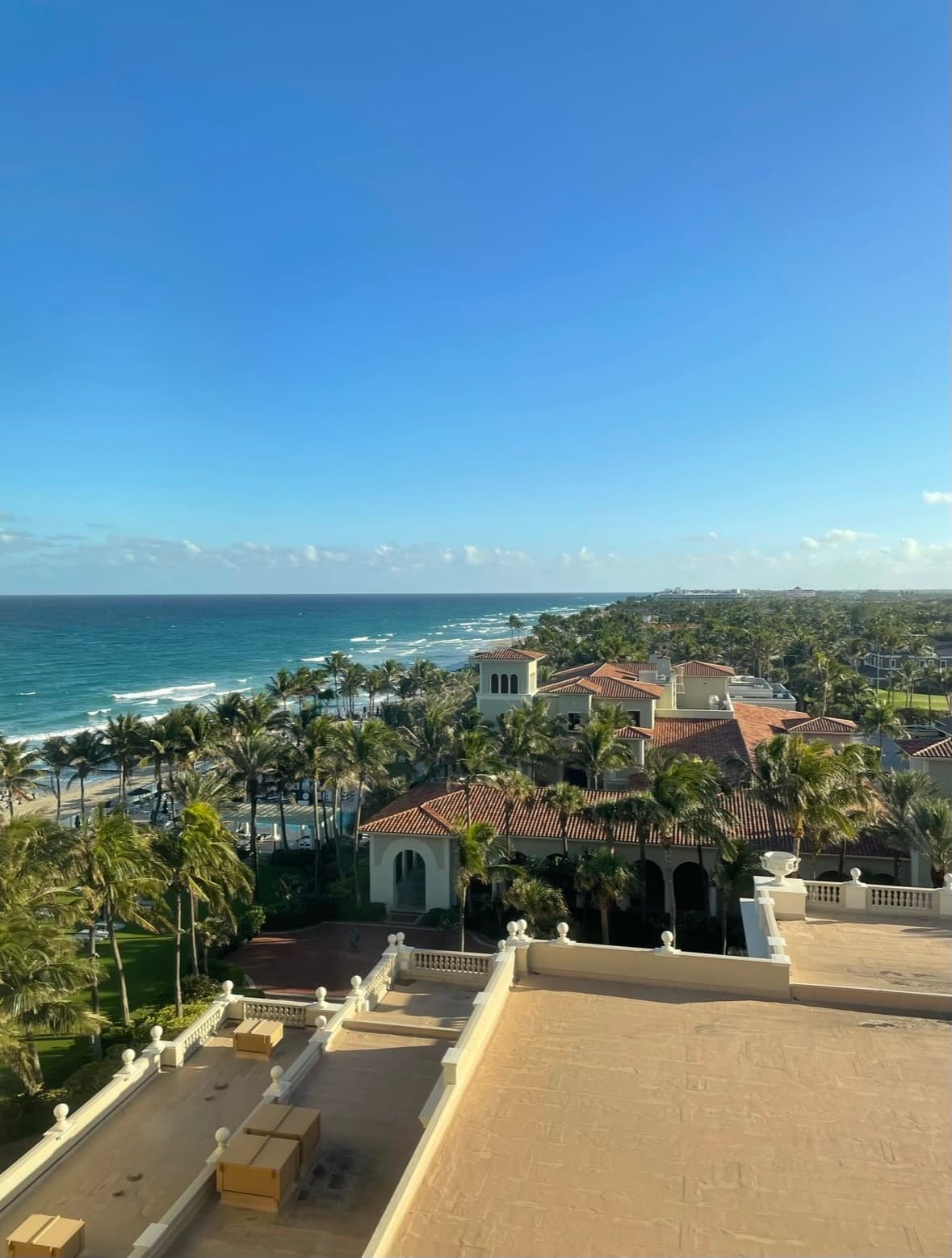 An aerial view of The Breakers Palm Beach hotel with the ocean and blue sky in the background