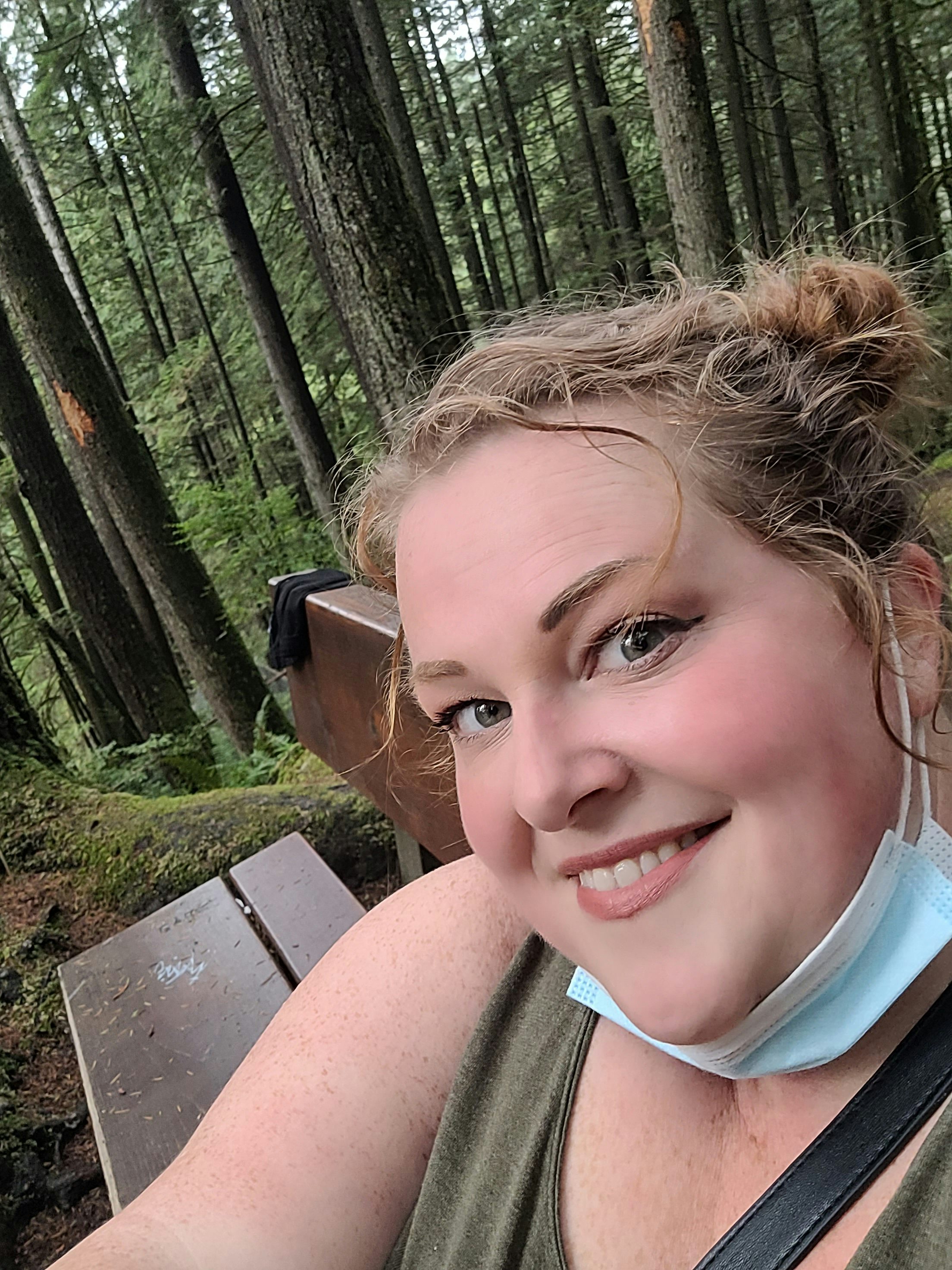 Travel Advisor Kymberly Forest on a park bench in the woods.