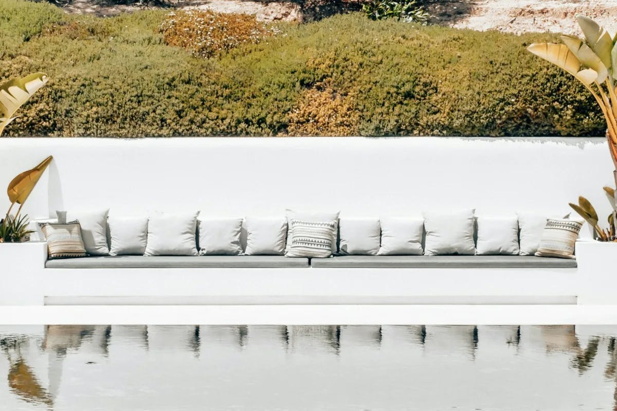 Plush outdoor furniture lines a whitewashed wall at a ritzy Ibiza resort