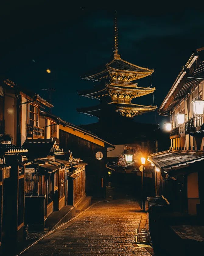 A pagoda at the end of a medieval alley at dusk.